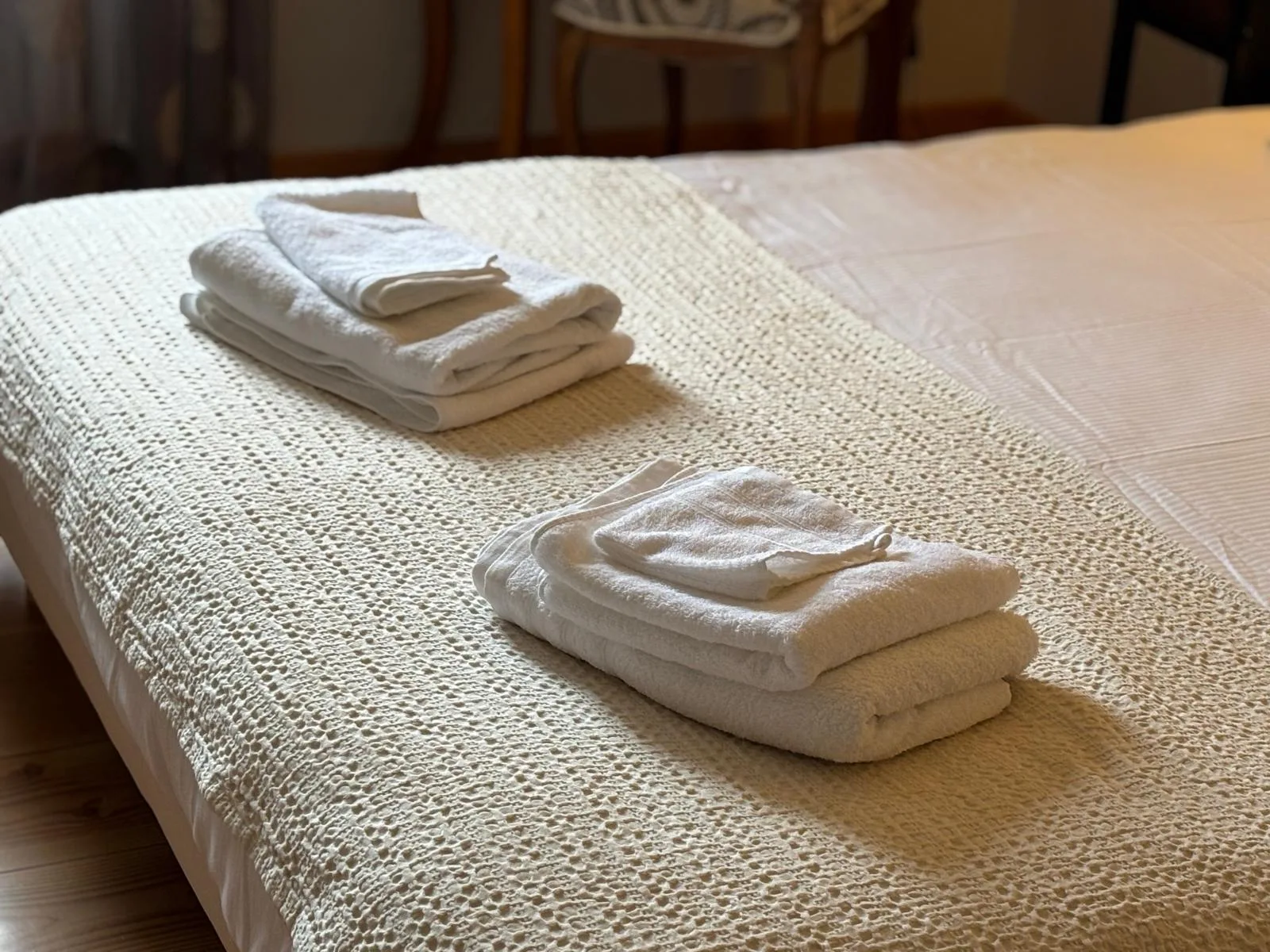 Asciugamani bianchi piegati sul letto, tocco alberghiero