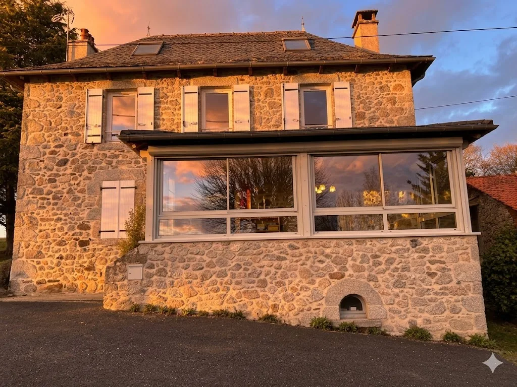 Facciata in pietra con veranda panoramica al tramonto — Gîte Angèle, Sénezergues